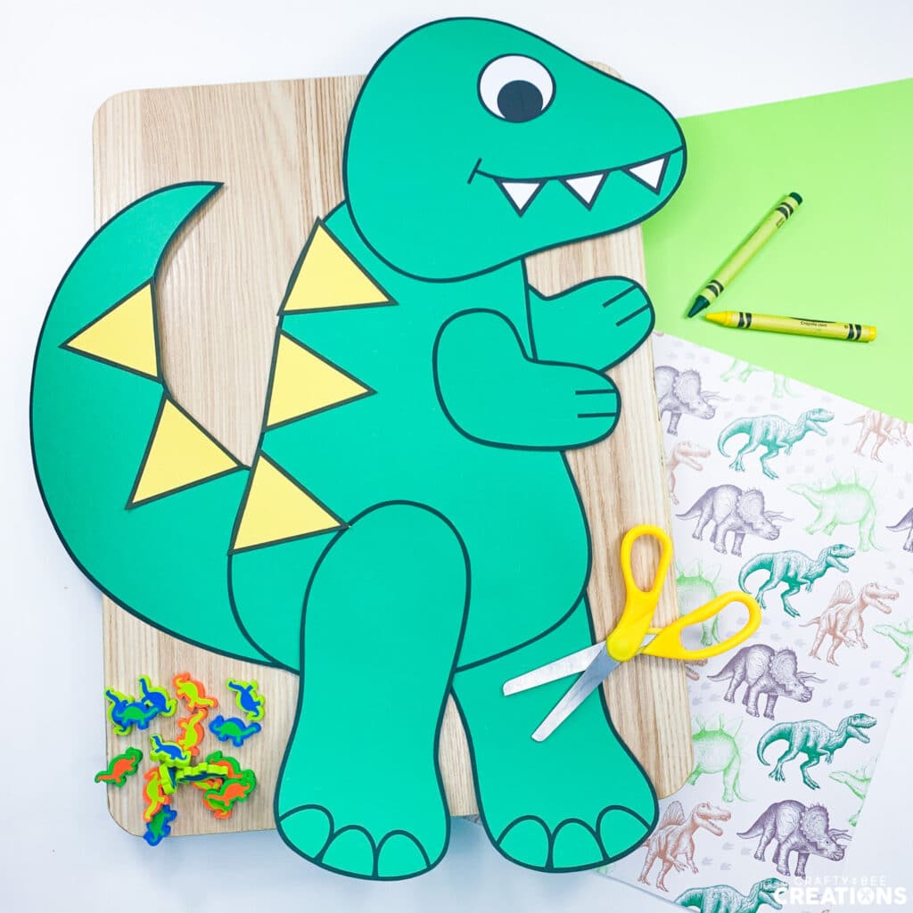 Tyrannosaurus Rex craft on wooden board with mini erasers, scissors and crayons.