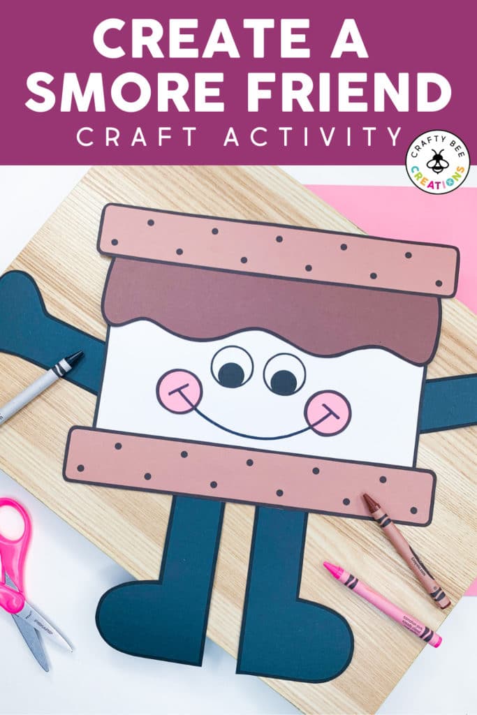 Create a Smore Friend Craft Activity. The smore craft is a brown graham cracker with melted chocolate and a white marshmallow. The smore friend has black arms and legs. There is a black, pink and brown crayon on the page, as well as pink scissors. The craft is lying on a wooden board.