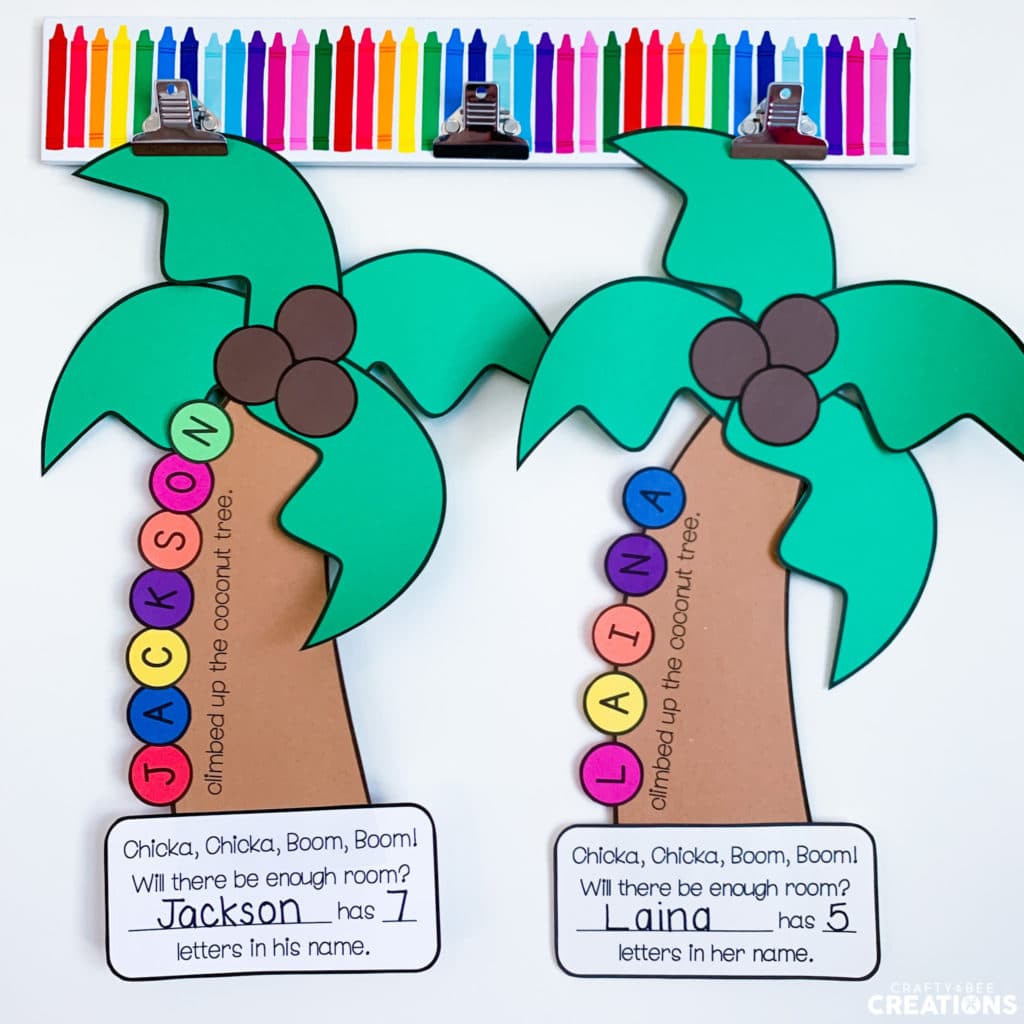 Two Coconut Tree Name Crafts hanging on clips in a classroom.